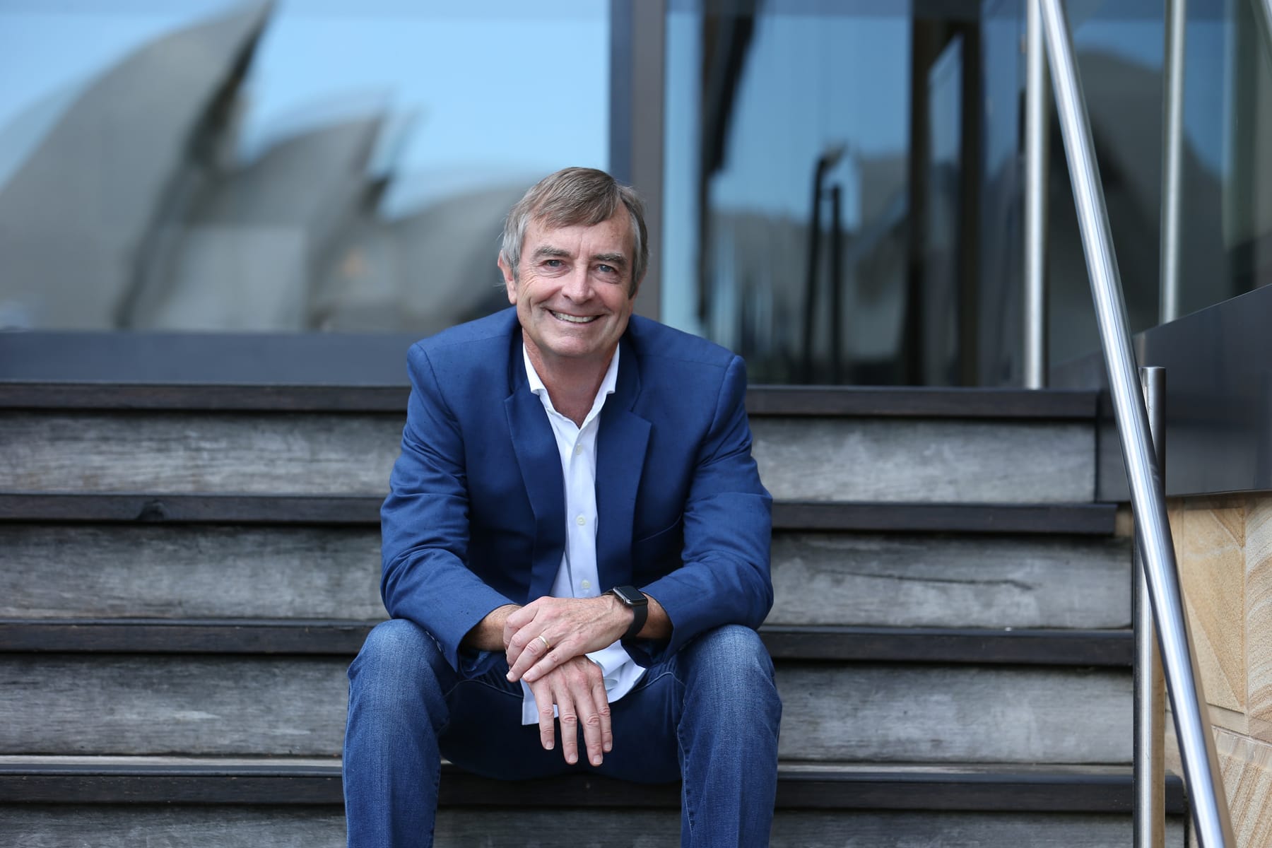Dane Hudson seated on the steps of the Sydney Opera House